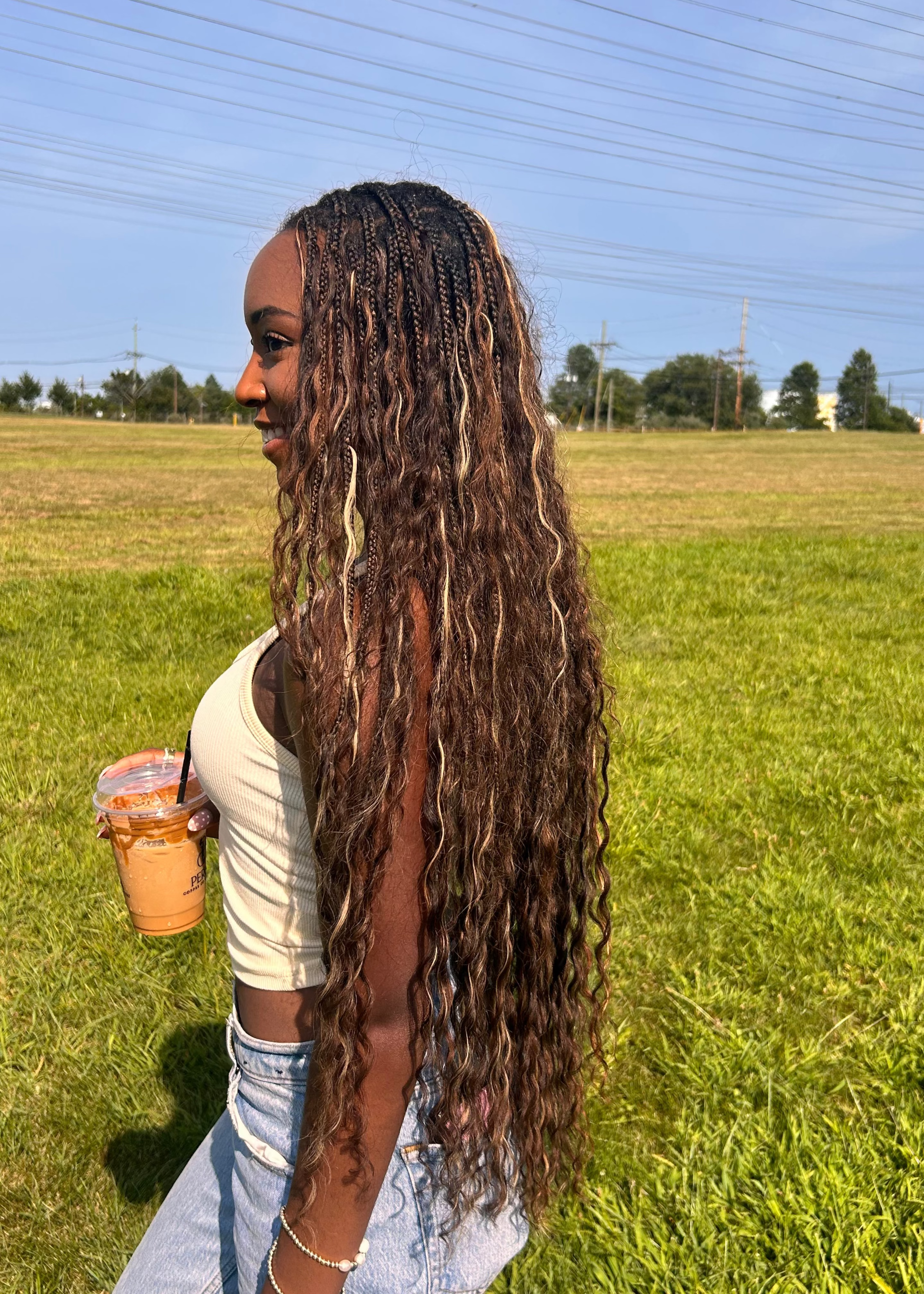 Person with long blonde boho braids in a wavy texture